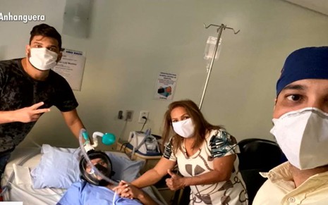 Cauan e a família de máscara visitando o pai no hospital