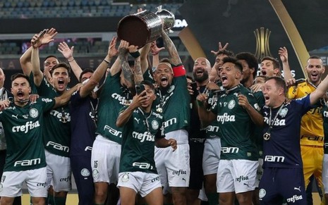 Jogadores do Palmeiras comemorando o título da Libertadores em volta da taça