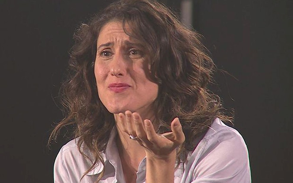 Paola Carosella de cabelo solto, cacheado, com cara de indignação nos bastidores do MasterChef Brasil