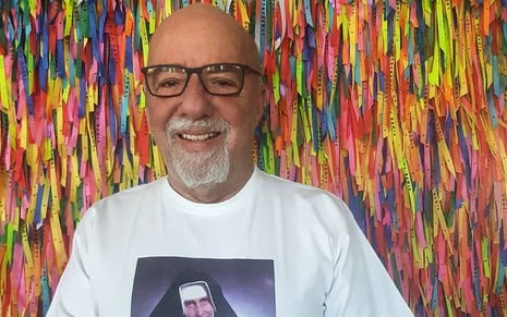 Paulo Coelho sorri em frente a tirinhas do Senhor do Bonfim em foto publicada no Instagram