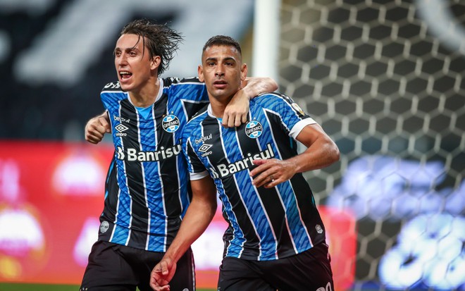 Pedro Geromel e Diego Souza comemoram gol do Grêmio, lado a lado, vestidos com uniforme do time nas cores azul, preto e branco