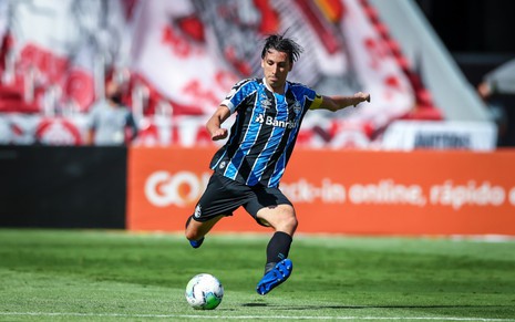 O jogador do Grêmio, Pedro Geromel em lance no campo, vestido com o uniforme do time nas cores azul, preto e branco