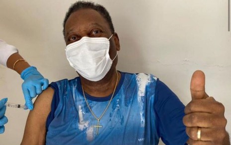 Pelé faz sinal de joia ao ser vacinado contra a Covid-19 em sua casa no Guarujá
