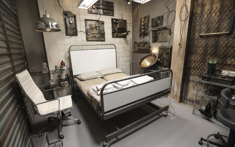 Imagem do quarto Perrengue, do Power Couple Brasil 5, que simula um leito de hospital psiquiátrico abandonado, com duas macas
