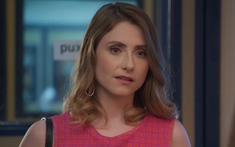 A atriz Bruna Guerin com uma regata rosa e expressão confusa em cena como Petra na novela Salve-se Quem Puder