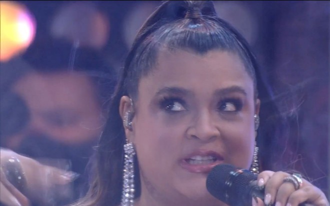 Preta Gil segura microfone e olha para cima enquanto canta em sua apresentação no BBB21