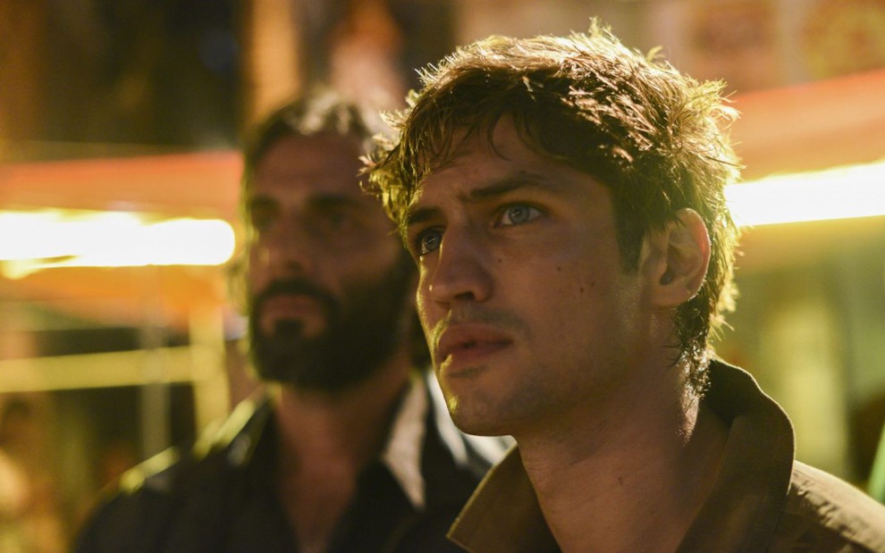 Os atores Flávio Tolezani e Gabriel Leone olham sério para o lado em cena de Dom