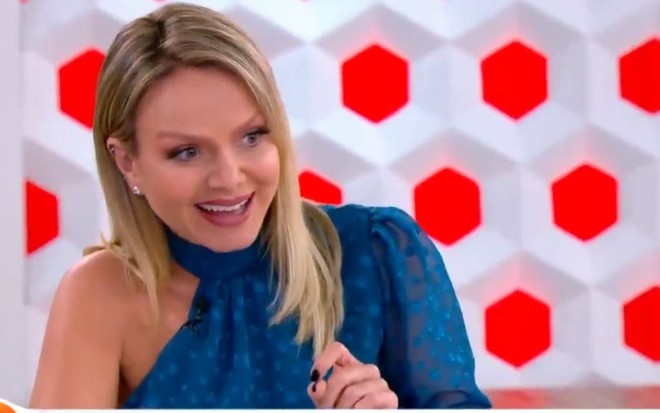 Sorridente e vestida de azul, Eliana apresenta seu programa dominical no estúdio do SBT