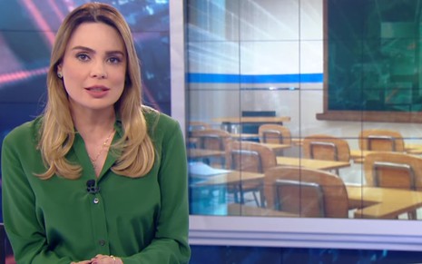 Rachel Sheherazade vestindo uma camisa verde na bancada de um telejornal