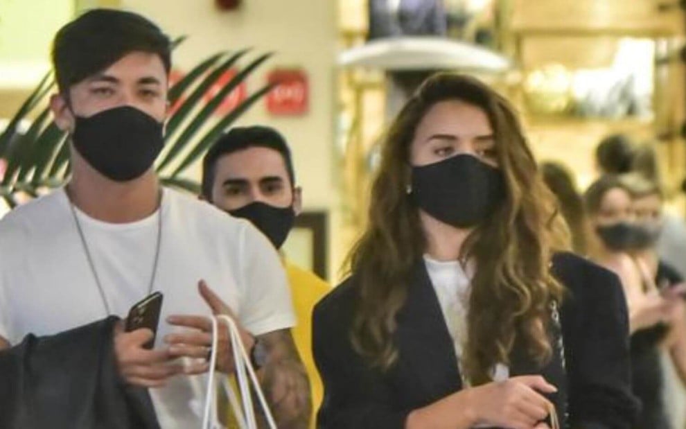 De máscara preta, Daniel Caon e Rafa Kalimann passeiam no shopping Cidade Jardim, em São Paulo