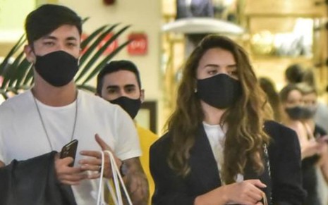 De máscara preta, Daniel Caon e Rafa Kalimann passeiam no shopping Cidade Jardim, em São Paulo