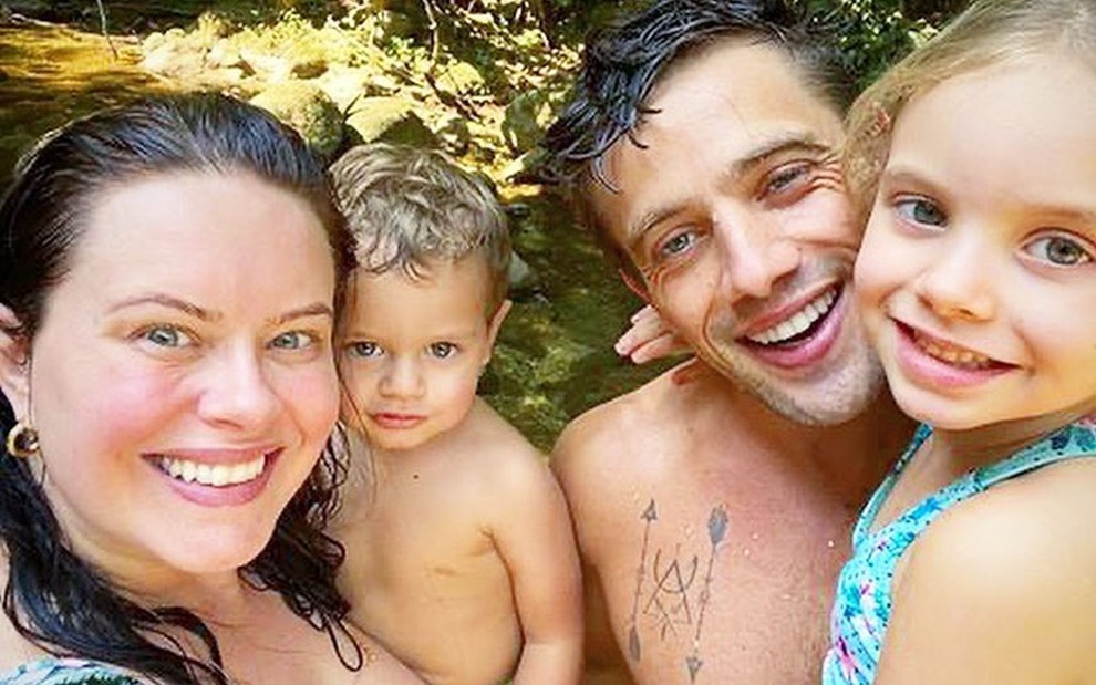 Mariana Bridi, Rafael Cardoso, Aurora e Valentim sorridentes em banho de cachoeira