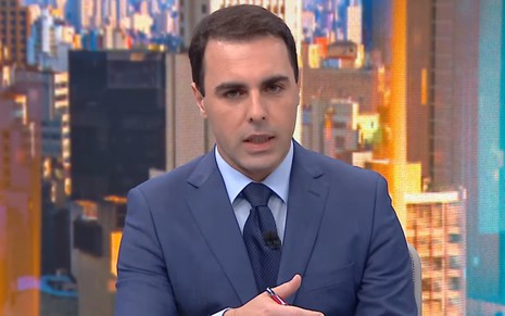 Rafael Colombo com a boca semiaberta, gesticulando com a mão, na CNN Brasil