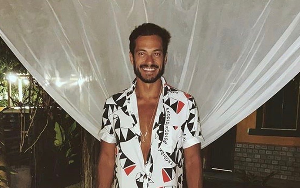 Raphael Vianna sorrindo, usando uma camisa florida