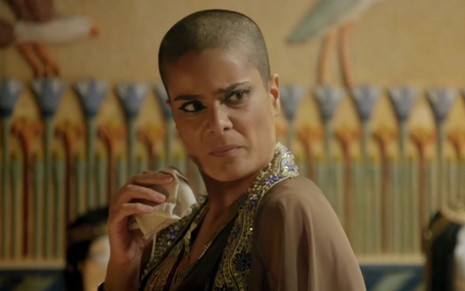 Bianka Fernandes em cena de Gênesis: caracterizada como Aat, atriz olha com desconfiança para alguém fora do quadro