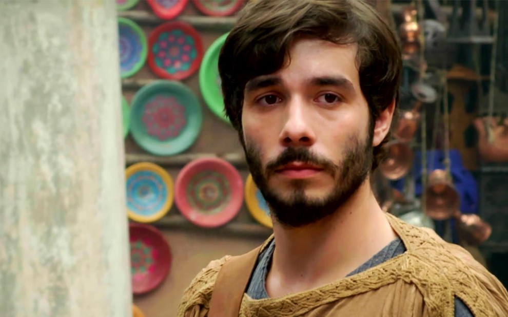Vitor Novello em cena de Gênesis: caracterizado como Abrão, ator olha de maneira séria para alguém fora do quadro