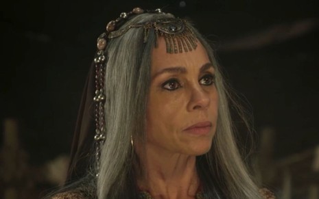 Carla Marins interpreta Adália em cena Gênesis: atriz olha com surpresa com alguém fora do quadro