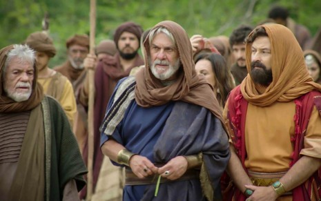 Zécarlos Machado em cena de Gênesis: caracterizado como Abrão, ator está acompanhado de diversos atores que andam no deserto