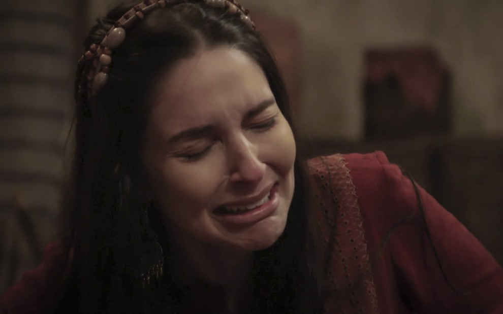 Laura Kuczynski com acessório na cabeça e chorando no papel de Danina, sua personagem em Gênesis, da Record