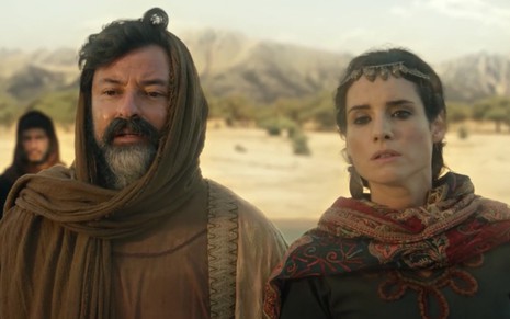 O ator Emilio Orciollo Netto como Ló à esquerda, com um deserto ao fundo, e a atriz Elisa Pinheiro como Ayla à direita em cena de Gênesis