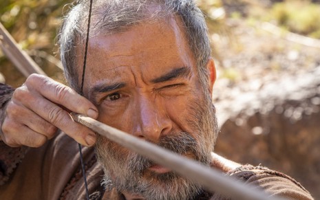 Ricardo Blat grava sujo e mirando com um arco e flecha como Lotam na novela Gênesis, da Record