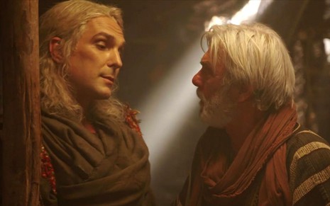 Igor Rickli e Zécarlos Machado em cena de Gênesis: caracterizados como Lúcifer e Abrão, personagens conversam entre si