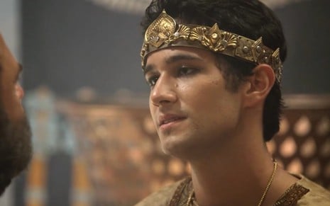 O ator Rafael Gevú com uma coroa de ouro, ele olha para a esquerda e está caracterizado como Dnim-Sim em cena de Gênesis