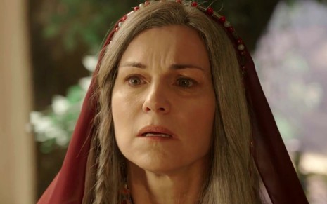 Adriana Garambone caracterizada como Sara em Gênesis, personagem encara com surpresa algo fora do quadro