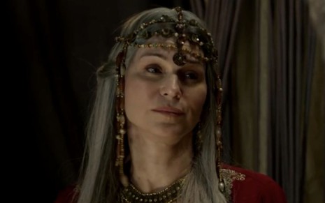 Adriana Garambone caracterizada como Sara em Gênesis, personagem encara algo fora do quadro