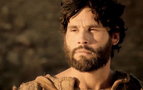 O ator Dudu Azevedo por uma paisagem pedregosa ao fundo caracterizado como Jesus em cena de Jesus