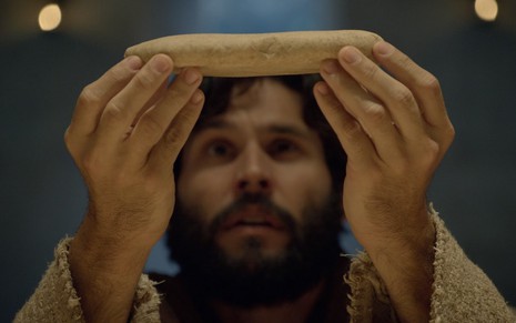 Jesus (Dudu Azevedo) segura pão em cena da Santa Ceia na novela bíblica da Record