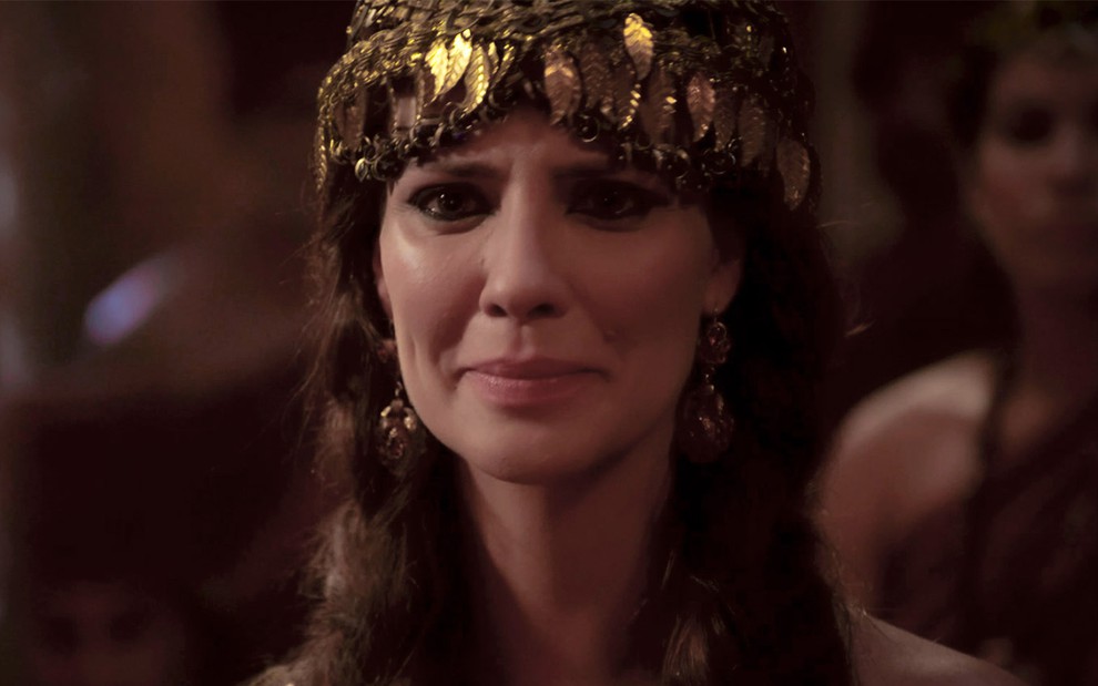 Camila Rodrigues em cena de Gênesis: caracterizada como Nadi, personagem usa adorno dourado na cabeça, maquiagem pesada ao redor dos olhos e olha com desespero para alguém fora do quadro