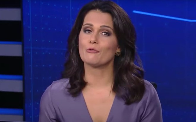 A apresentadora Adriana Araújo no cenário do Jornal da Record durante a edição de 21 de abril