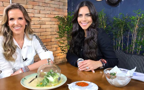 A jornalista Mariana Ferrão e a apresentadora Daniela Albuquerque em gravação de entrevista para o Sensacional, da RedeTV!, em uma mesa de jantar