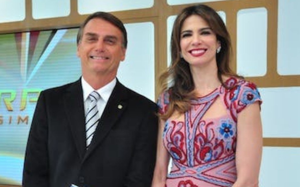 Foto do presidente Jair Bolsonaro (à esquerda) com a apresentadora Luciana Gimenez (à direita) no palco do programa Superpop, da RedeTV!, em 2016