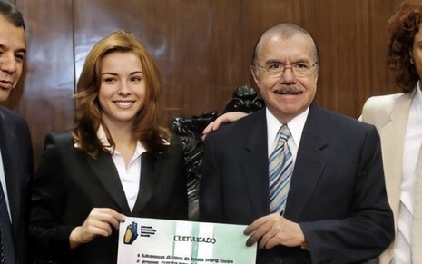 A atriz Regiane Alves segura um certificado junto do político José Sarney no plenário do Senado Federal