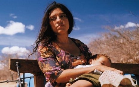 A atriz Regina Casé segura uma criança no colo em cena como a personagem Darlene no filme Eu, Tu, Eles (2000)