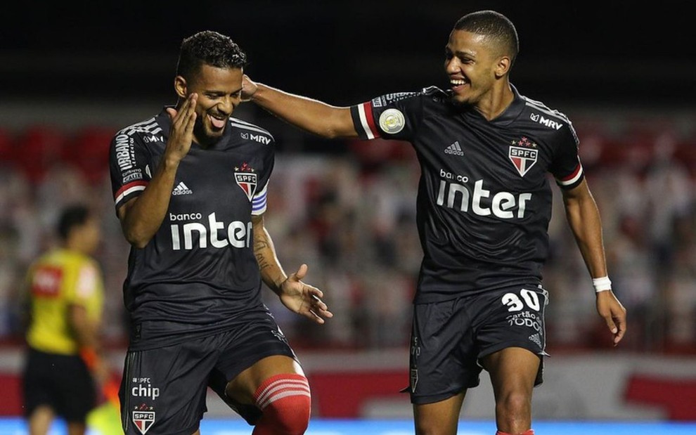 Sorridentes, Reinaldo e Brenner festejam gol pelo São Paulo; o lateral faz uma coreografia