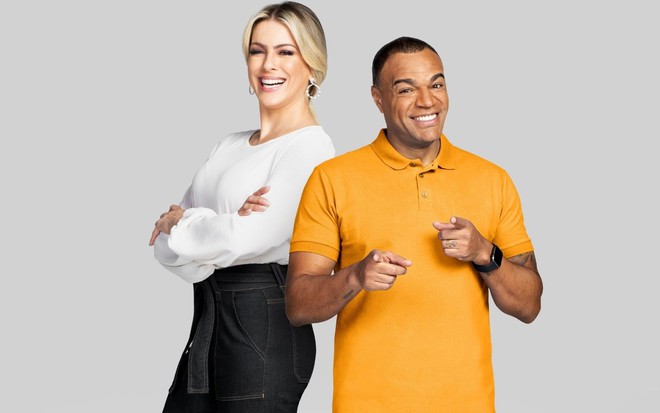 Renata Fan e Denilson no Jogo Aberto, um ao lado do outro, ela de branco e preto, e ele de amarelo