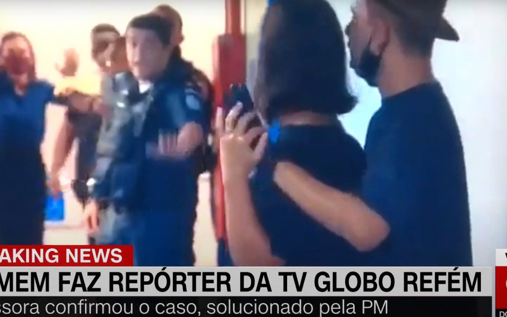 Á direita, Thomas Rosa (de boné) segura a repórter Marina Araújo que foi mantida como refém em prédio da Globo