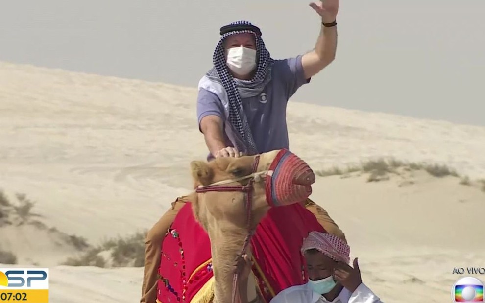 Renato Peters com turbante preto, em cima de um camelo em Doha, no Catar