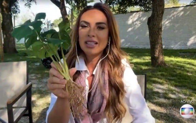 A modelo Nicole Bahls segura uma planta de plástico em participação no programa É de Casa, da Globo