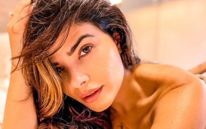 A atriz Vanessa Giácomo, com a mão segurando o cabelo