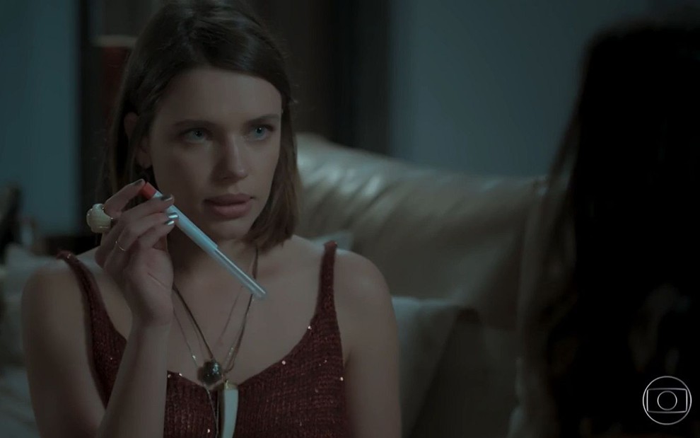 Cibele (Bruna Linzmeyer) com um tubo de teste de DNA na mão em cena de A Força do Querer