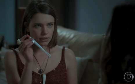 Cibele (Bruna Linzmeyer) com um tubo de teste de DNA na mão em cena de A Força do Querer