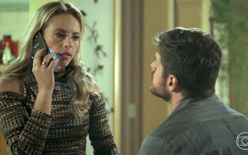 Jeiza (Paolla Oliveira) atende o celular diante de Zeca (Marco Pigossi) em cena de A Força do Querer