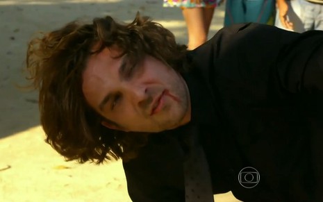 Alberto (Igor Rickli) caído no chão com a boca sangrando em cena de Flor do Caribe