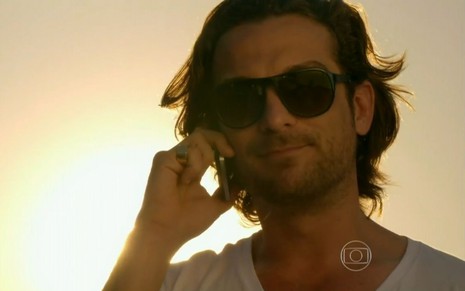 Alberto (Igor Rickli) fala ao telefone com óculos escuros em cena de Flor do Caribe