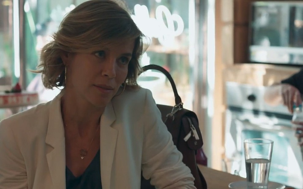Malu (Daniela Galli) sentada com um blazer branco em cena de Malhação - Viva a Diferença