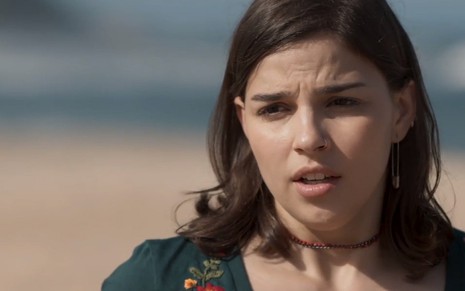 Keyla (Gabriela Medvedovski) com expressão tensa em uma praia em cena de Malhação